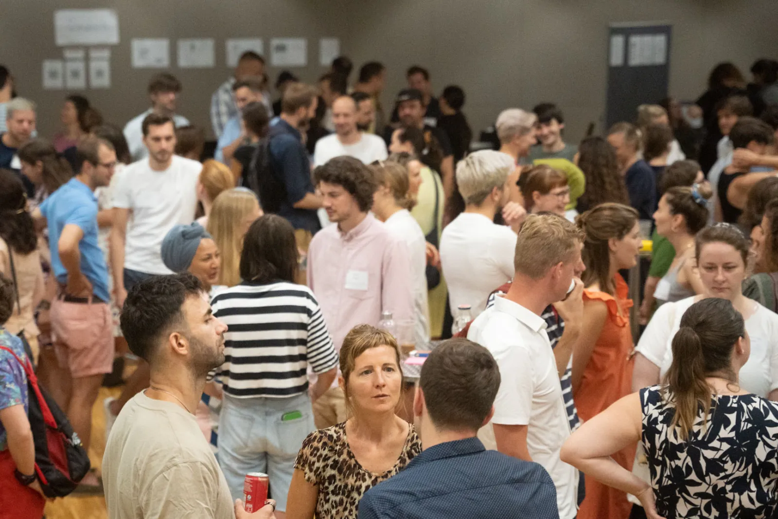 Menschenmenge auf einer Networking-Veranstaltung in einem großen Saal, sie führen Gespräche.
