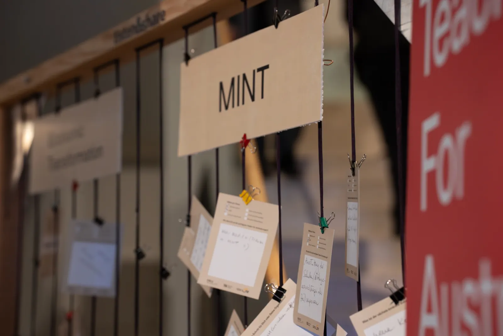 Ausstellungsdisplay mit Schild MINT und vielen Notizkarten an Schnüren.